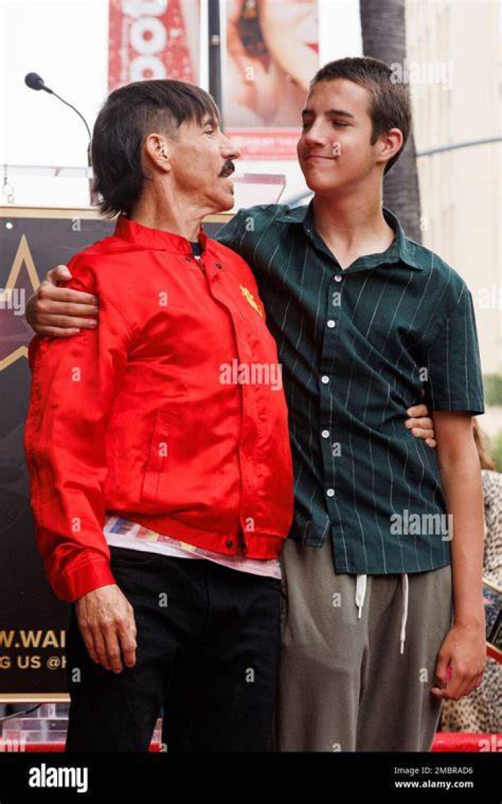 Anthony Kiedis greets son Everly Bear with a kiss while picking him up
